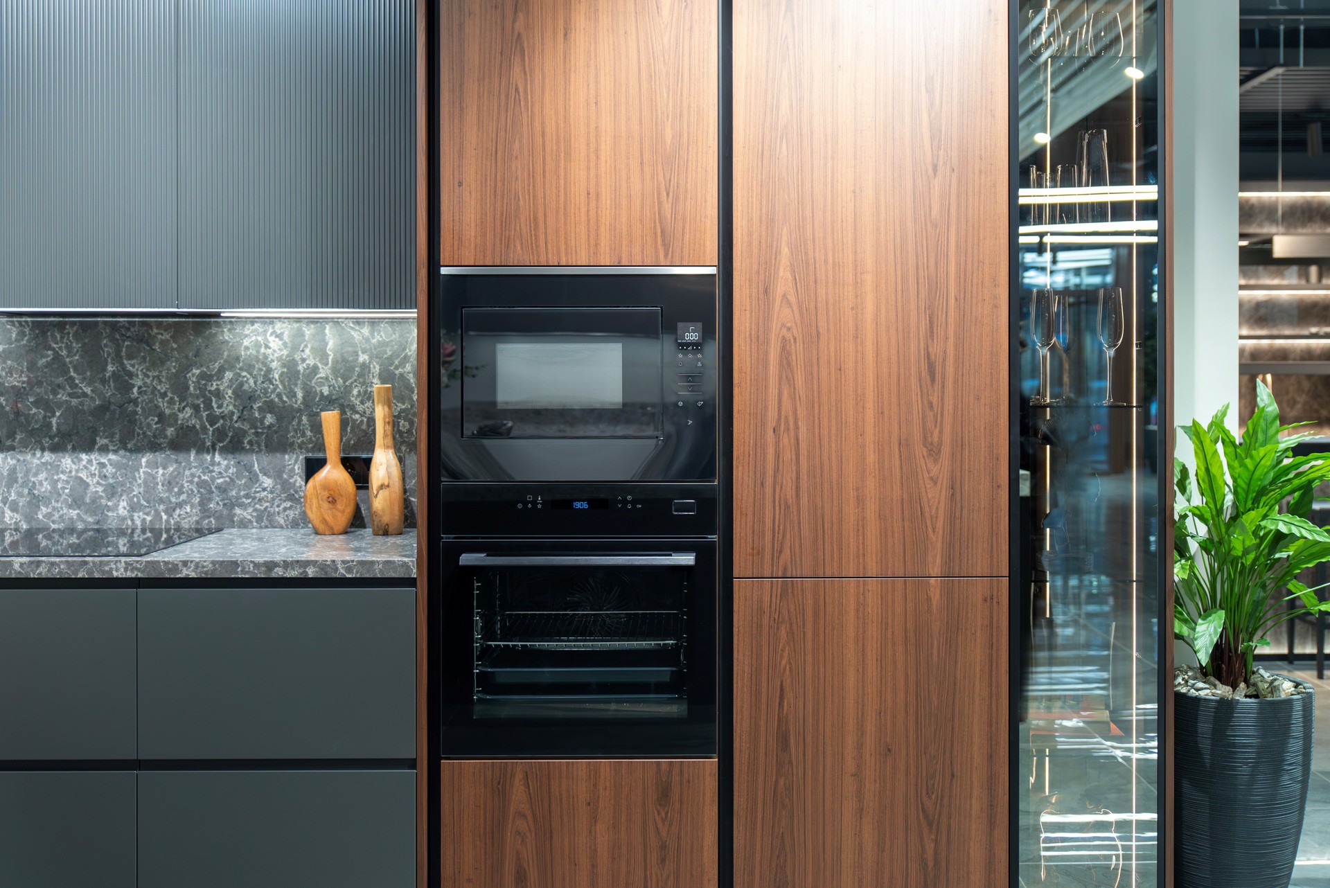 Built-in kitchen appliances: black oven and microwave in a wooden kitchen